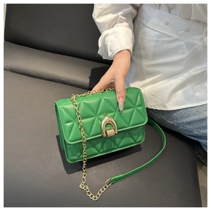 Vue détaillée du sac bandoulière matelassé vert avec chaîne dorée et boucle en métal