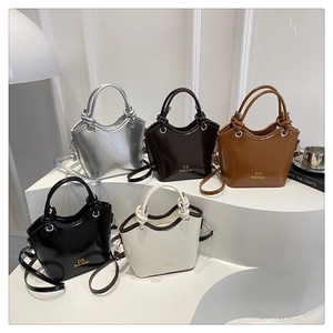 Minimalist bucket bags in silver, coffee, caramel, black and beige on display stands