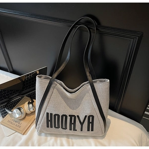 Detail of the HOORYA canvas tote bag with black leather straps on a white background