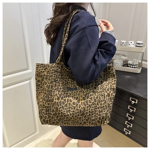 Close-up of leopard print canvas tote bag featuring a black rectangular woven label detail