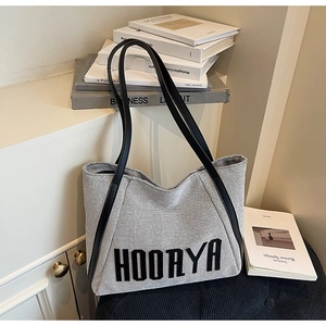 Detail of Hoorya canvas tote bag showing black and white woven texture and slim handles