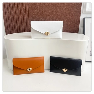 Detailed display of envelope clutch bags in white, tan, and black with gold metal buckles