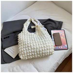 Detail of white cloud pleated tote bag with lace bow decoration and bubble texture fabric