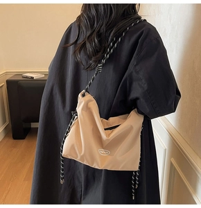 Detail of light khaki nylon messenger bag with woven rope strap and GAIFYUN logo