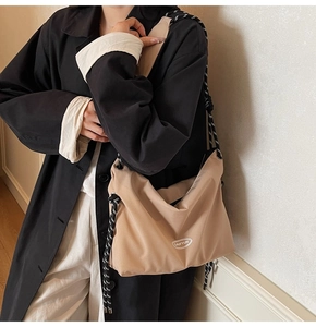 Detail of khaki large crossbody bag with thick knotted rope strap and logo design