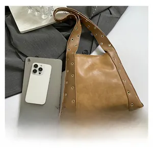 Détail du sac cabas en cuir beige avec œillets dorés et grande capacité de rangement