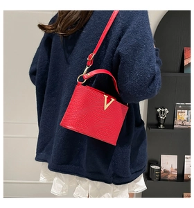 Détail du sac carré matelassé rouge avec boucle métallique dorée en forme de V