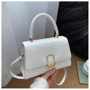 Detail of white crocodile texture baguette bag with a golden oval metal buckle and strap
