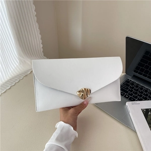 Chic white envelope clutch bag with gold abstract buckle shown in a lifestyle setting