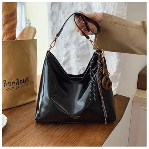 Detail of black large-capacity Hobo bag with glossy PU leather and golden text