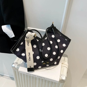 Polka dot tote bag with wide strap displayed on a suitcase for stylish daily commute