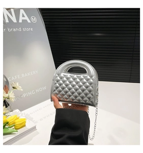 Detail of silver quilted mini bag featuring metallic finish and chain strap