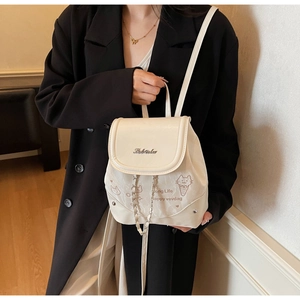 Detail of cream PU leather backpack with cat print and metallic chain accent for women