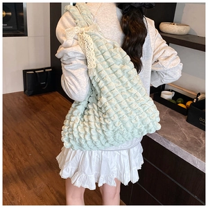 Detail of mint green pleated bubble tote bag featuring a delicate white lace bow detail