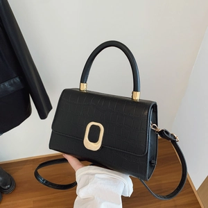 Chic black crocodile pattern baguette bag with a golden clasp and sturdy top handle