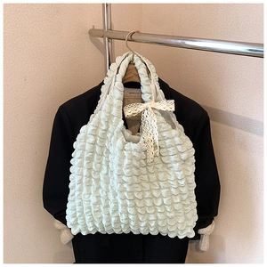 Detail of mint green cloud pleated tote bag with bubble texture and lace bow decor