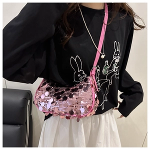 Detail of pink sequin crescent bag showing reflective round scales and leather strap