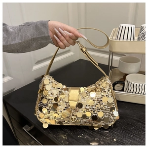 Détail du sac demi-lune doré avec sequins brillants et fine bandoulière en cuir