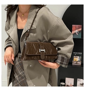 Détail d'un sac à bandoulière vintage marron avec texture plissée et boucle en métal argenté