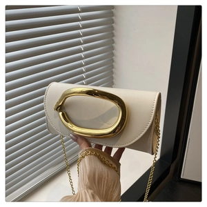 Detail of a creamy white flap clutch featuring a unique wavy gold metal ring handle