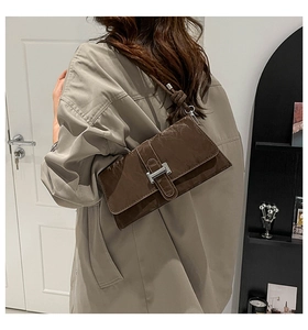 Mannequin portant un sac baguette en cuir plissé marron foncé avec fermoir argenté