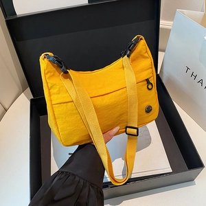 Fashionable bright yellow nylon crossbody bag with black strap in a stylish gift box