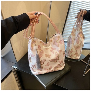 Detail of pink tote bag with butterfly embroidery and soft tassel pompom keychain