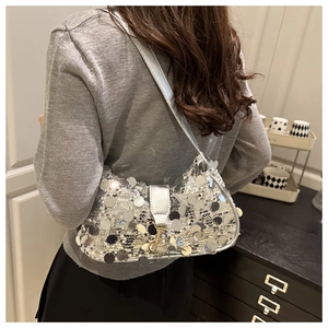 Détail d'un sac à bandoulière à paillettes argentées avec grands disques et boucle en métal