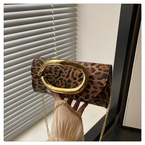 Detail of leopard print clutch featuring a large gold buckle and fine chain strap