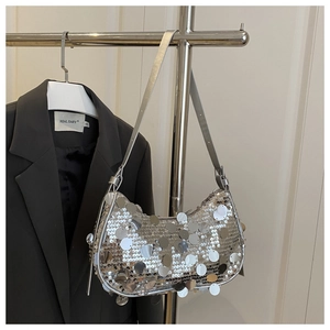 Detailed view of silver sequin hobo bag with round metallic discs and leather strap