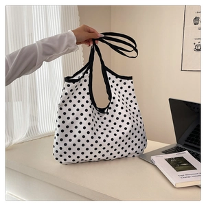 Vue détaillée d'un grand sac fourre-tout en toile à pois noirs dans un décor moderne
