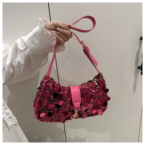 Détail d'un sac à main rose à paillettes avec sangle en cuir et finitions métalliques