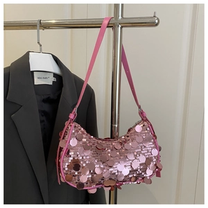 Detail of pink sequin baguette bag with adjustable leather strap and crescent shape