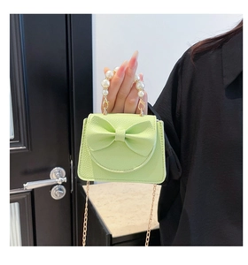 Detail of mint green quilted mini bag with imitation pearl handle and golden chain strap