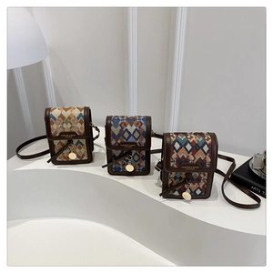 Detailed view of vintage jacquard square bags with geometric patterns and gold charms