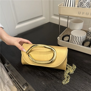Elegant champagne gold satin evening clutch bag with oval metal handle and chain strap