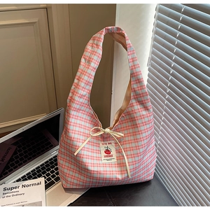 Dettaglio della borsa tote in tela a quadretti rosa e blu con etichetta di pomodoro