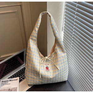 Dettaglio borsa tote a scacchi gialli e blu con etichetta pomodoro e coulisse decorativa