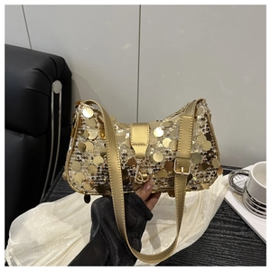 Détails des paillettes dorées sur un sac demi-lune avec une bandoulière métallique assortie