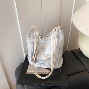 Elegant off-white shoulder bag with blue butterfly embroidery and decorative tassel