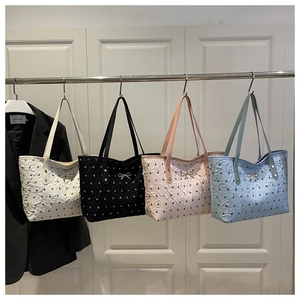 Detail view of colorful bubble textured tote bags with delicate gold bow accents