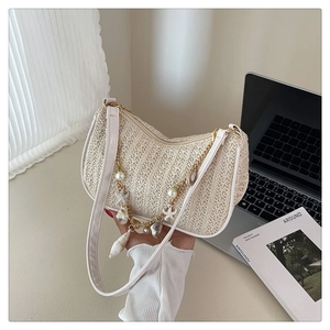 Detail of straw shoulder bag featuring sea shells, pearls and starfish charms