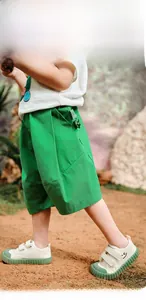 Detail of green cocoon kids shorts featuring 3D cat paw decor and breathable texture