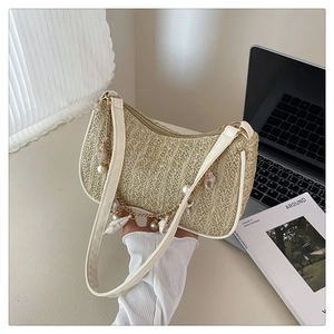 Detail of woven straw bag with pearl shell chain and beige leather shoulder strap