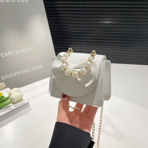 White pebbled leather mini crossbody bag with a large bow and pearl handle for girls