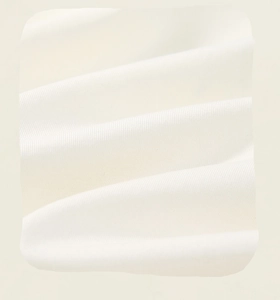 Close-up of high-quality ivory white cotton fabric showing detailed woven texture and softness