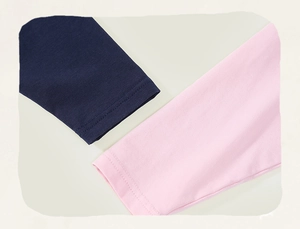 Detail of baby girl cotton tee showing navy and pink contrast cuffs with fine stitching