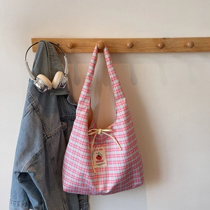 Minimalist pink and green plaid canvas tote bag with bow tie on wooden hook