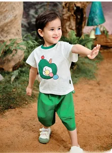 Detail of kids summer cotton set featuring white t-shirt with green apple print and shorts