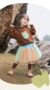 Dettaglio maglione in maglia con toppa a rana e gonna in tulle colorato per bambine